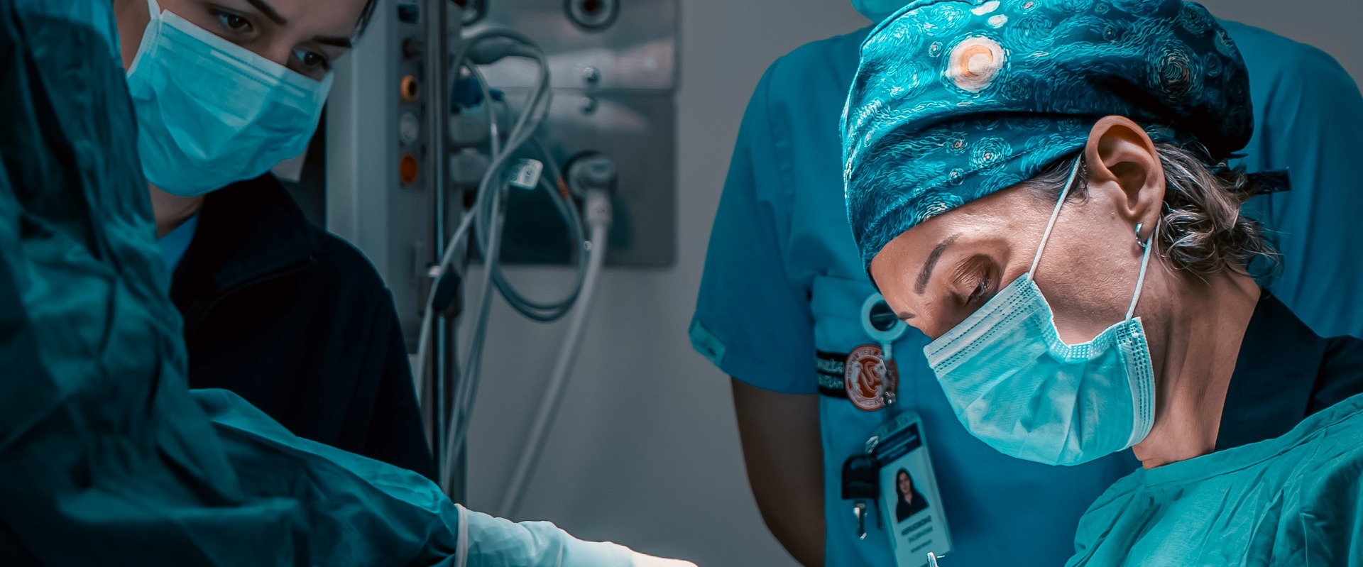 Surgical team in blue scrubs and masks working together during an operating room procedure
